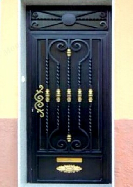 Puerta escalera con barrote trabajado a fragua y adornos de laton.